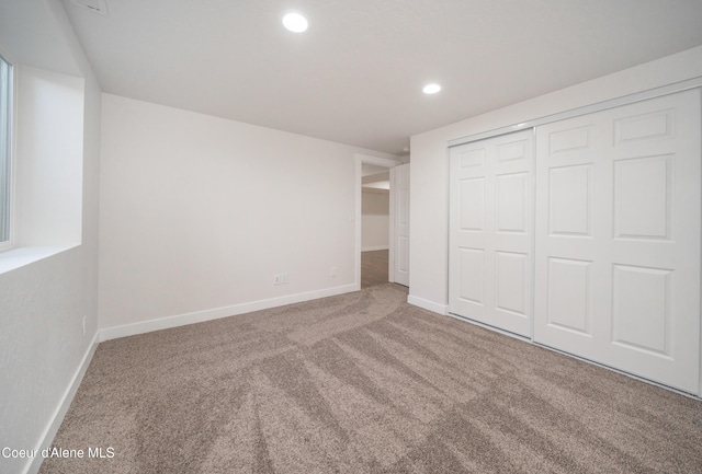 unfurnished bedroom with baseboards, carpet floors, recessed lighting, and a closet