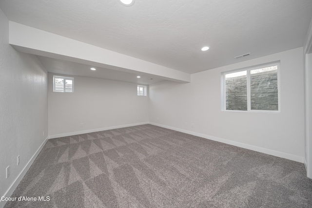 below grade area featuring baseboards, visible vents, carpet floors, and recessed lighting