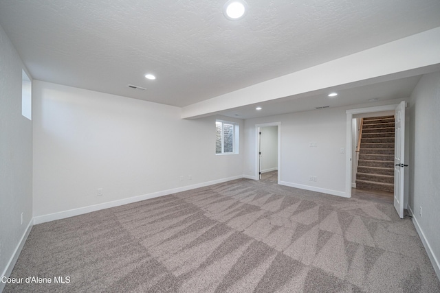 basement featuring carpet, stairs, visible vents, and recessed lighting