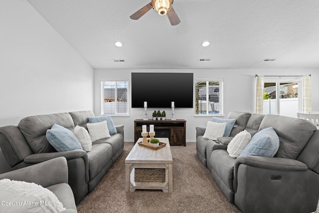 living room featuring a ceiling fan, visible vents, and a wealth of natural light