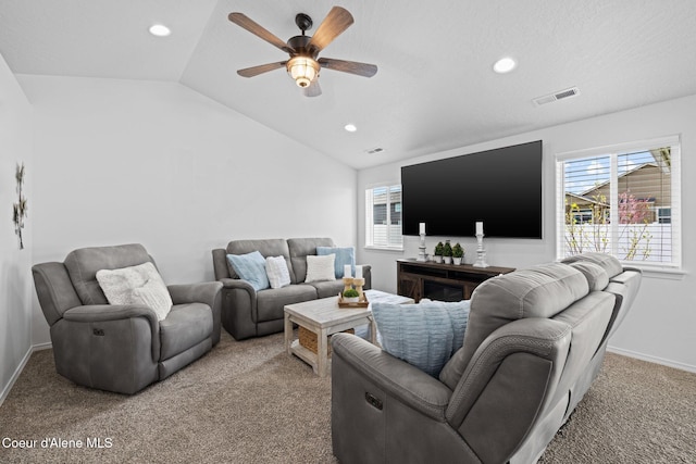 living room featuring visible vents, light carpet, a wealth of natural light, ceiling fan, and vaulted ceiling