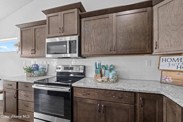 kitchen featuring backsplash, stainless steel appliances, dark brown cabinetry, and lofted ceiling