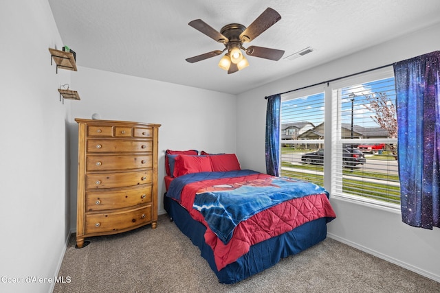 carpeted bedroom with baseboards, visible vents, and ceiling fan