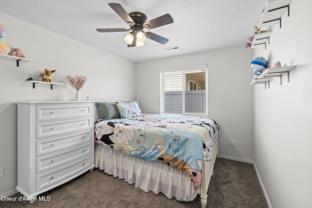 bedroom featuring ceiling fan, a textured ceiling, visible vents, baseboards, and dark carpet