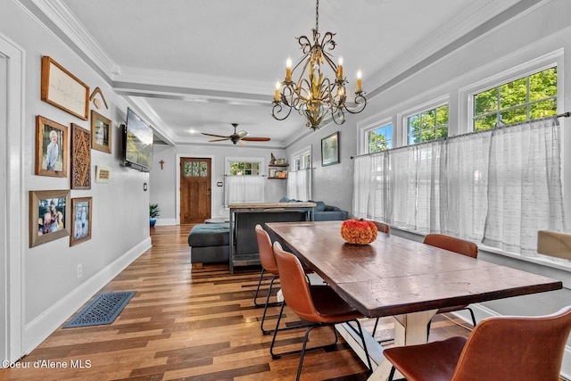 dining area with crown molding, visible vents, wood finished floors, and ceiling fan with notable chandelier