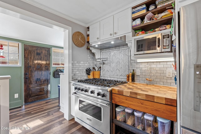 kitchen featuring backsplash, wood finished floors, white cabinets, ornamental molding, and stainless steel appliances