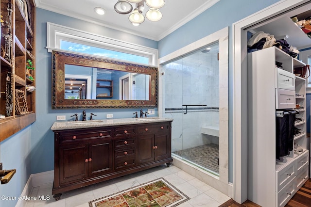 bathroom with a sink, crown molding, and a stall shower