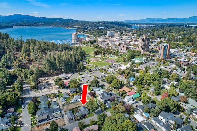 birds eye view of property with a wooded view and a water and mountain view