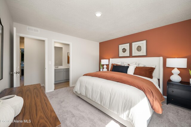 120 E Spirea Ln, Hayden, ID 83835 - carpeted bedroom with ensuite bath, a textured ceiling, visible vents, and baseboards