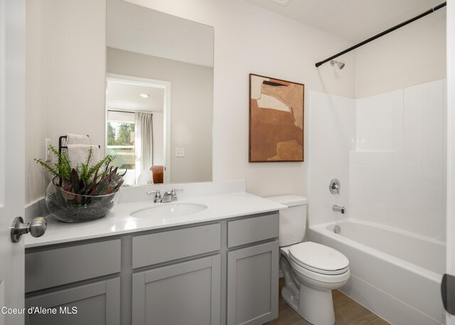 120 E Spirea Ln, Hayden, ID 83835 - bathroom featuring toilet, vanity, wood finished floors, and bathing tub / shower combination
