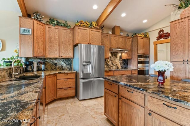 kitchen featuring a sink, dark stone counters, appliances with stainless steel finishes, and tasteful backsplash