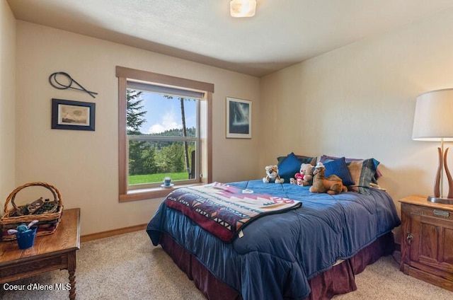 bedroom with baseboards and light colored carpet