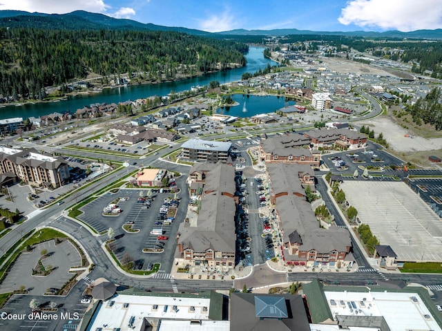 drone / aerial view featuring a forest view and a water and mountain view