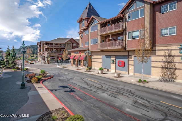 view of road featuring curbs, street lights, sidewalks, and a residential view