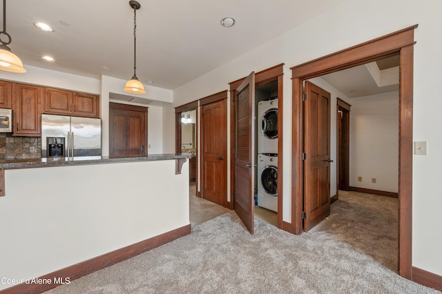 kitchen featuring stainless steel fridge, light carpet, recessed lighting, stacked washer / dryer, and white microwave