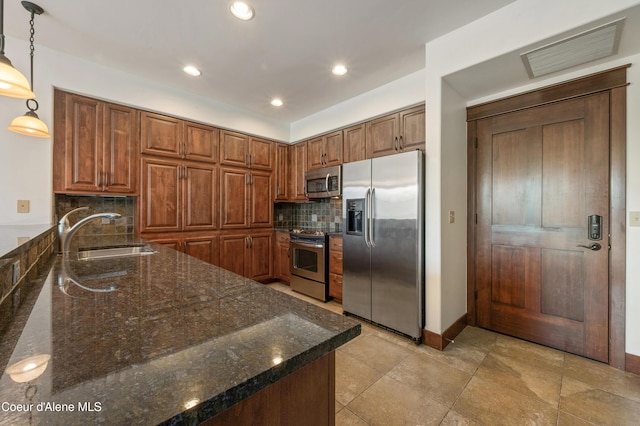 kitchen featuring visible vents, tasteful backsplash, a sink, dark stone countertops, and appliances with stainless steel finishes