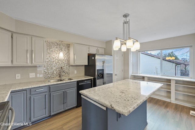956 N Armstrong Dr, Coeur Dalene, ID 83814 - kitchen featuring stainless steel appliances, a sink, backsplash, white cabinetry, and light wood-style flooring