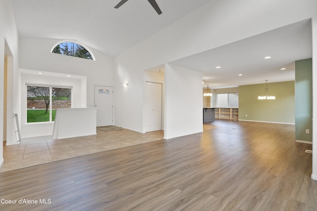 956 N Armstrong Dr, Coeur Dalene, ID 83814 - unfurnished living room with a chandelier, healthy amount of natural light, ceiling fan, wood finished floors, and high vaulted ceiling
