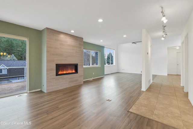 956 N Armstrong Dr, Coeur Dalene, ID 83814 - unfurnished living room featuring a tile fireplace, wood finished floors, recessed lighting, and baseboards