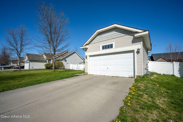 exterior space featuring a lawn, fence, and a garage
