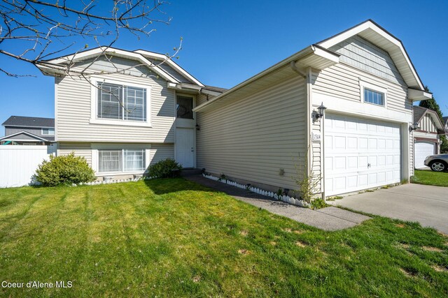 split level home with fence, driveway, and a front yard