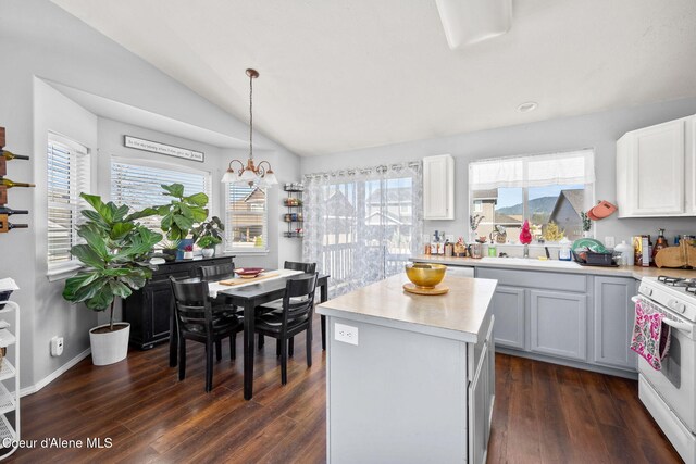 kitchen featuring light countertops, white gas stove, dark wood-style flooring, and a sink