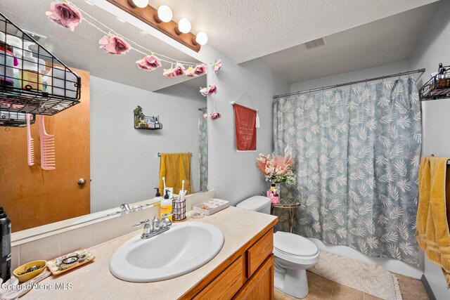 bathroom with vanity, toilet, tile patterned floors, shower / bathtub combination with curtain, and visible vents