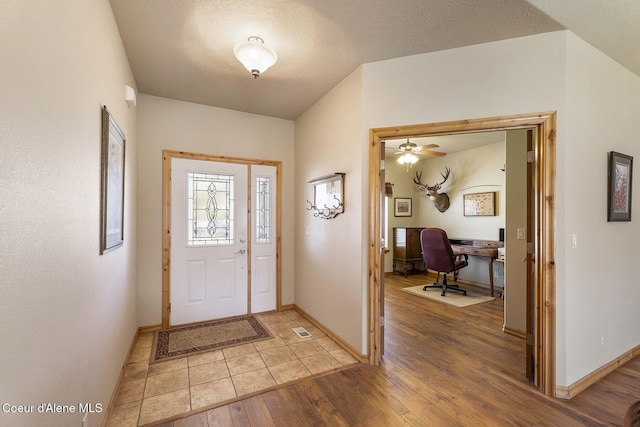 entrance foyer with baseboards, a ceiling fan, and light wood-style flooring