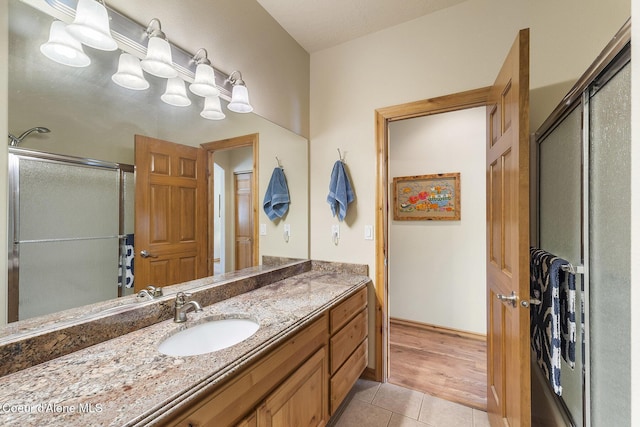 bathroom with an enclosed shower, tile patterned floors, and vanity