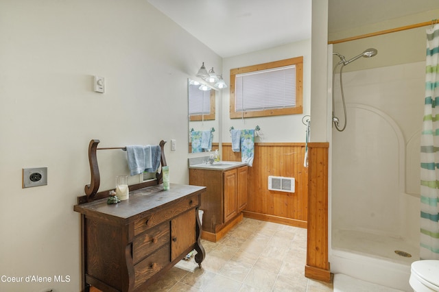 bathroom featuring wooden walls, visible vents, vanity, wainscoting, and a stall shower