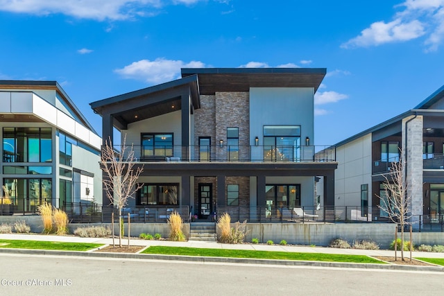 3132 N Atlas Rd, Coeur Dalene, ID 83814 - back of property with a porch, stone siding, and a balcony