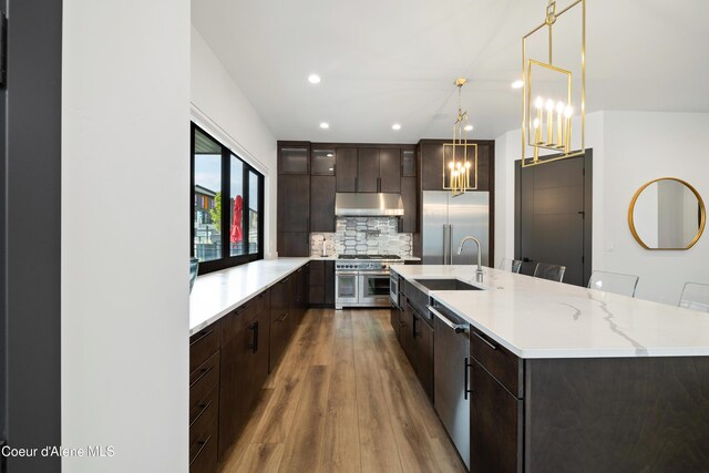 3132 N Atlas Rd, Coeur Dalene, ID 83814 - kitchen with a sink, dark brown cabinetry, premium appliances, light countertops, and under cabinet range hood