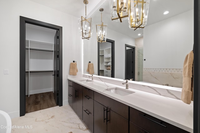 3132 N Atlas Rd, Coeur Dalene, ID 83814 - full bath with a walk in closet, an inviting chandelier, a sink, and double vanity