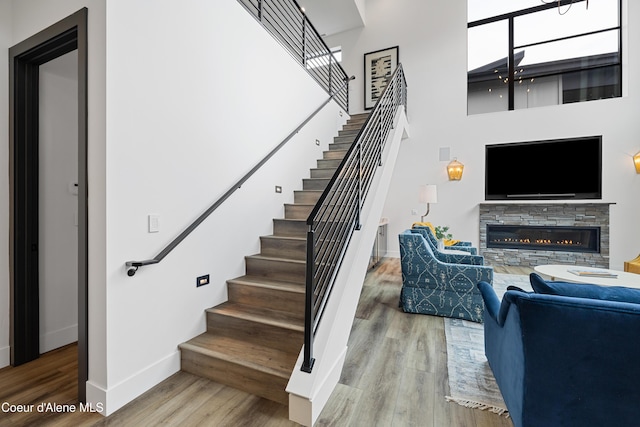 3132 N Atlas Rd, Coeur Dalene, ID 83814 - staircase with a fireplace, wood finished floors, a towering ceiling, and baseboards