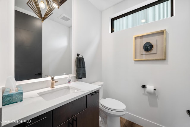 3132 N Atlas Rd, Coeur Dalene, ID 83814 - bathroom with wood finished floors, visible vents, toilet, vanity, and baseboards