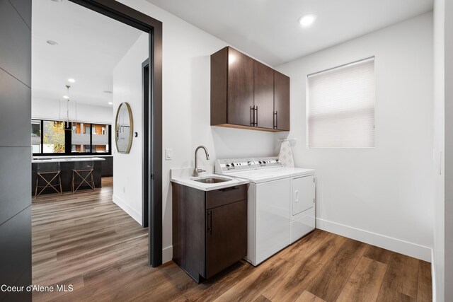 3132 N Atlas Rd, Coeur Dalene, ID 83814 - washroom with washer and clothes dryer, wood finished floors, a sink, cabinet space, and baseboards