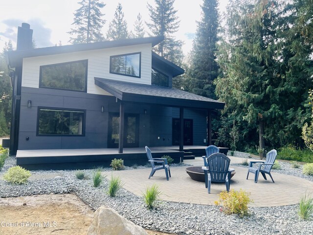 70 Wedge Ct, Priest Lake, ID 83856 - rear view of house featuring a patio area, an outdoor fire pit, and roof with shingles