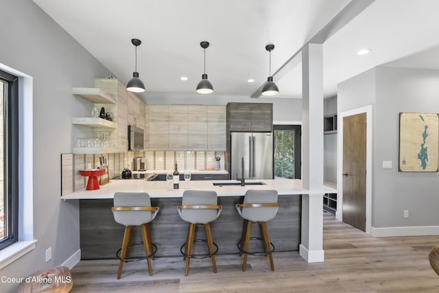 70 Wedge Ct, Priest Lake, ID 83856 - kitchen with a peninsula, tasteful backsplash, modern cabinets, light countertops, and appliances with stainless steel finishes