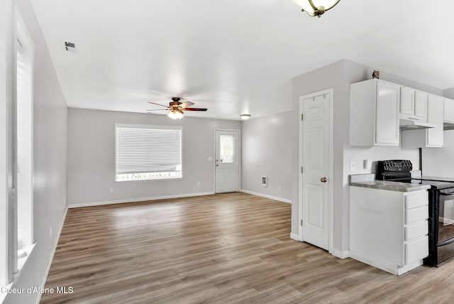 1002 E St Elias Ct, Post Falls, ID 83854 - kitchen with black range with electric stovetop, white cabinets, baseboards, light wood-type flooring, and a ceiling fan