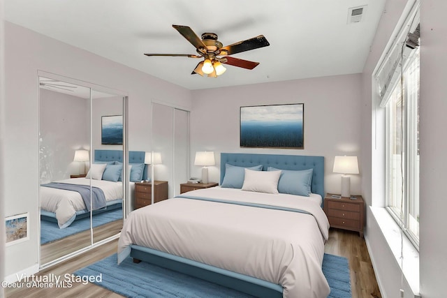1002 E St Elias Ct, Post Falls, ID 83854 - bedroom featuring a ceiling fan, visible vents, multiple closets, and wood finished floors