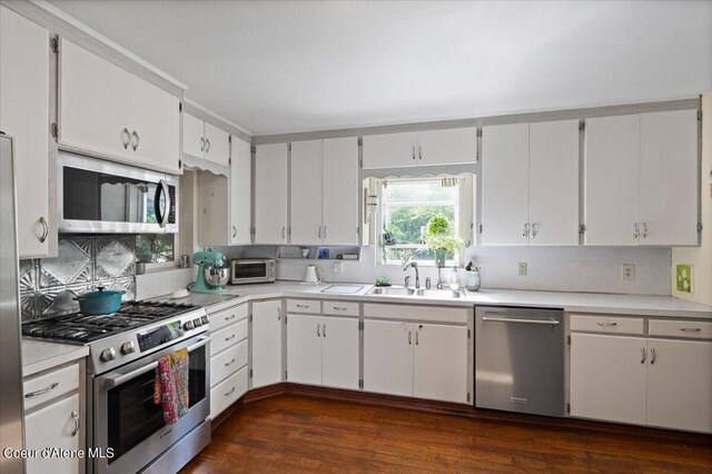 917 E Young Ave, Coeur Dalene, ID 83814 - kitchen with stainless steel appliances, light countertops, dark wood-style flooring, a sink, and decorative backsplash