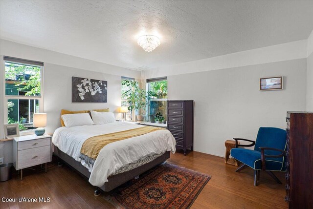 917 E Young Ave, Coeur Dalene, ID 83814 - bedroom featuring dark wood finished floors, multiple windows, and a textured ceiling