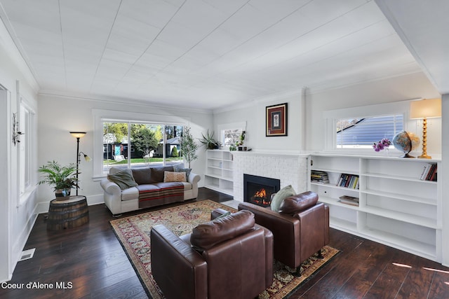 living area featuring wood-type flooring, a brick fireplace, visible vents, and ornamental molding
