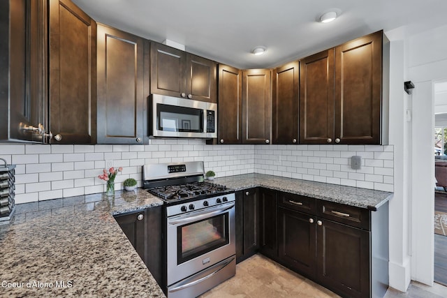 kitchen featuring dark brown cabinets, decorative backsplash, stone counters, and appliances with stainless steel finishes