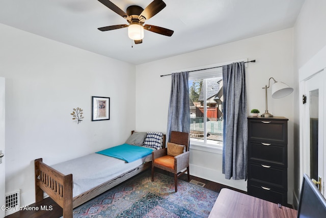 bedroom with visible vents, baseboards, wood finished floors, and ceiling fan