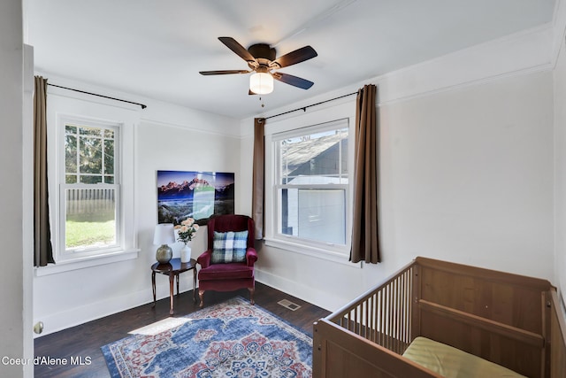 bedroom featuring baseboards, wood finished floors, visible vents, and ceiling fan