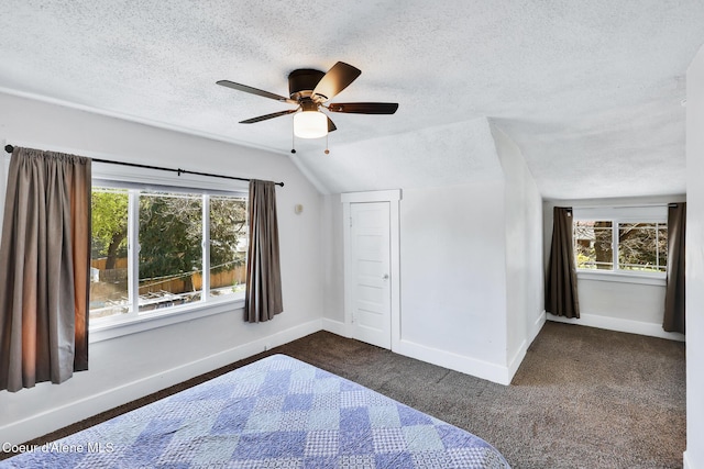 unfurnished bedroom with dark colored carpet, a textured ceiling, and multiple windows