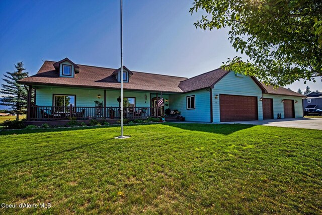 ranch-style home with a garage, a porch, a front lawn, and concrete driveway