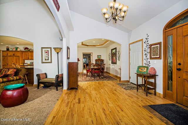 entrance foyer with arched walkways, an inviting chandelier, light wood-style flooring, baseboards, and recessed lighting