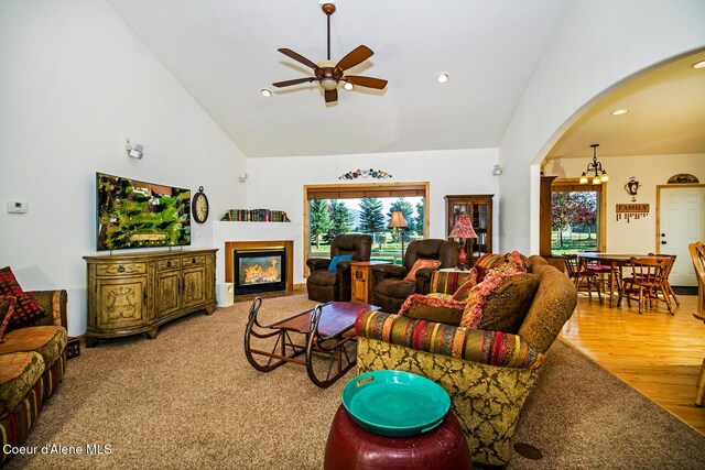 living room featuring arched walkways, a healthy amount of sunlight, high vaulted ceiling, and ceiling fan